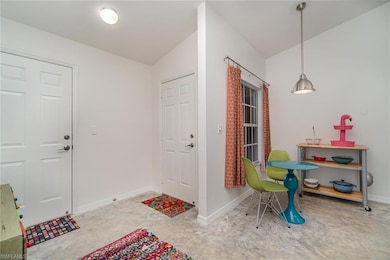 View of front door and garage door, concrete floor