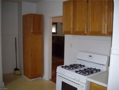 this kitchen offers appliances and a pantry cupboa