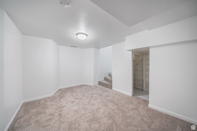 Finished basement with carpet floors and stairway