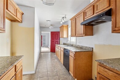 Galley style kitchen with granite counters, wood c