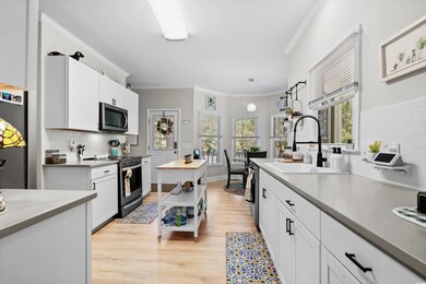 Kitchen with white cabinetry, sink, stainless stee