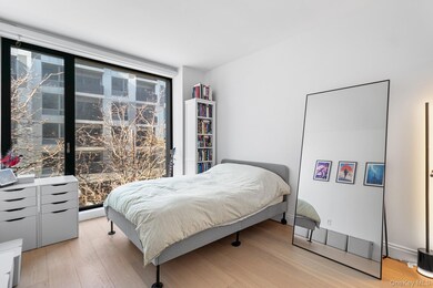 Bedroom with light wood-type flooring and a wall of windows