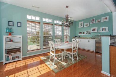 The Best ever Morning Room ~ windows with transoms and wood blinds, bronze chandelier, custom wet bar with wine refrigerator and beer tap with door leading to the back deck and brick paver patio and fire pit!