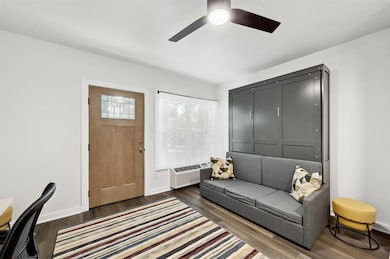 Living area with wood finished floors, ceiling fa