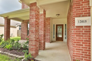 Brick house entrance with covered porch, wooden leaded glass front door with Ring Doorbell, landscaped garden.