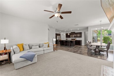 Living area with baseboards, ceiling fan with nota