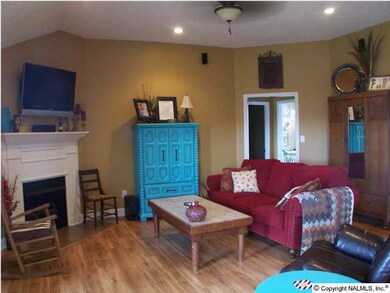 Living room with gas fireplace, ceiling fan and recessed lights.