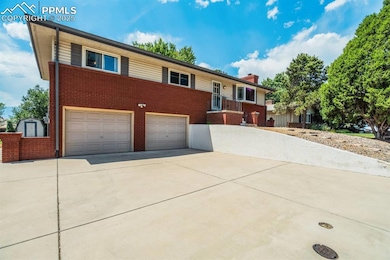 Ranch-style house featuring brick siding, driveway, an attached garage, and a chimney