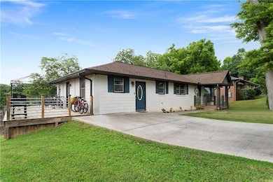 Single story home with a front lawn, concrete driveway, and roof with shingles