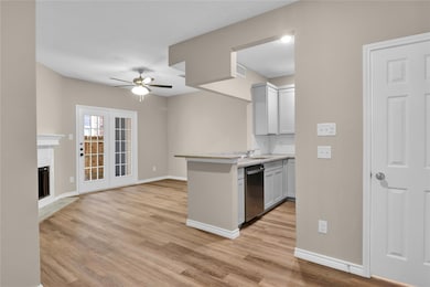 Kitchen featuring ceiling fan, light wood-style fl