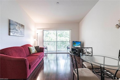 Living room with a textured wall and hardwood / wood-style flooring