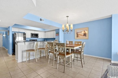 Dining space with an inviting chandelier, baseboar
