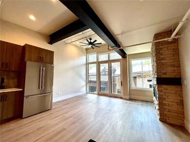 Unfurnished living room featuring beamed ceiling,