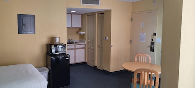 Kitchen featuring dark colored carpet, electric pa