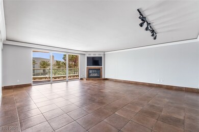 Unfurnished living room featuring rail lighting, a fireplace, ornamental molding, baseboards, and dark tile patterned floors