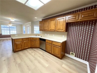 Kitchen with stainless steel dishwasher, light woo
