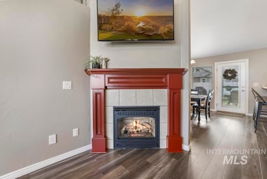 Living area featuring a tile fireplace and dark wood-style flooring