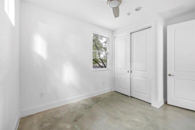 Unfurnished bedroom with concrete floors, baseboa