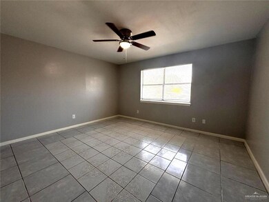 Empty room with a ceiling fan, baseboards, and tile patterned flooring