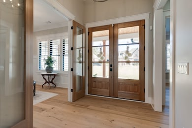 Natural wood accents throughout the home are well-suited for the surroundings.  Multiple sets of glass and wood doors grace the sitting room/office, primary suite, and laundry/drop zone spaces.