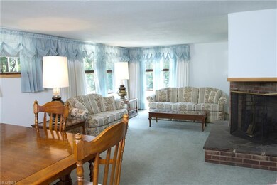 Living room with brick fireplace at an angle.