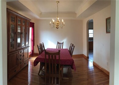 Formal Dining Room with tray ceiling and hardwood 