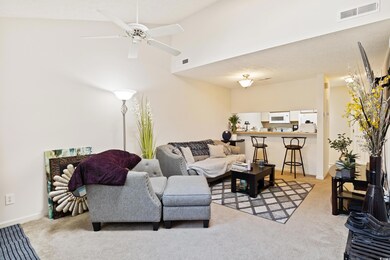 Carpeted living room featuring high vaulted ceilin