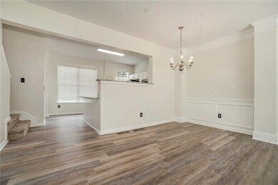 Unfurnished dining area with a chandelier, stairs, and wood finished floors