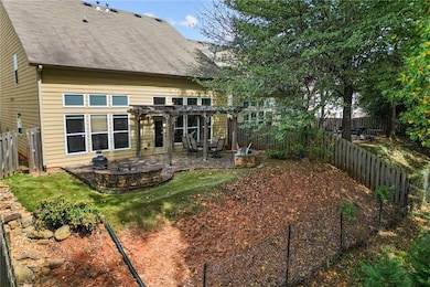 Rear view of house featuring a pergola, a fenced backyard, and a patio area