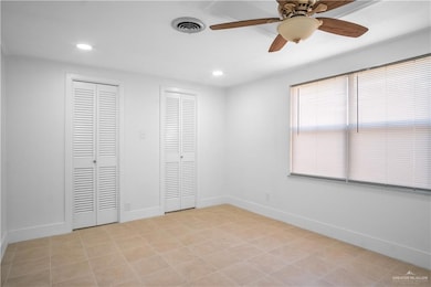 Unfurnished bedroom featuring multiple closets, a ceiling fan, recessed lighting, and light tile patterned floors