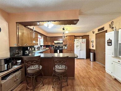 Kitchen with black gas stove, white refrigerator w