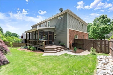 Relax and entertain in this expansive backyard featuring a screened patio and deck—perfect for gatherings and quiet moments alike.