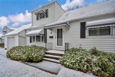 View of front of property featuring an attached garage and roof with shingles