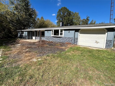 Ranch-style house featuring a chimney, a garage, and a front yard