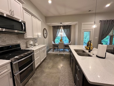 Kitchen with stainless steel appliances, a sink, tasteful backsplash, pendant lighting, and recessed lighting
