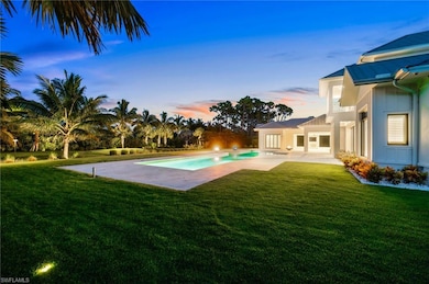 Pool at dusk with a patio and a lawn