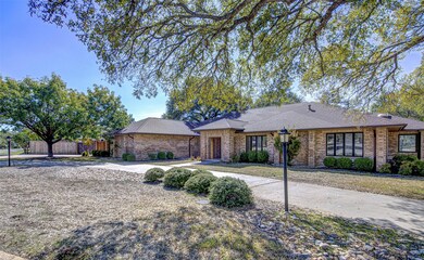 View of front facade featuring a shingled roof and brick siding