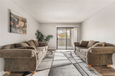 Living room featuring wood finished floors and a textured ceiling