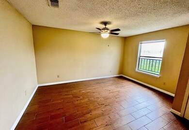 Unfurnished room with dark wood-style floors, a textured ceiling, and a ceiling fan