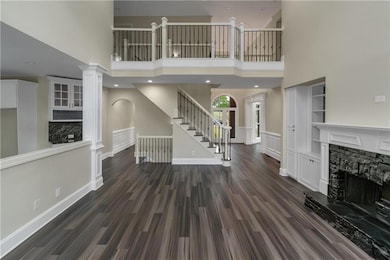 Unfurnished living room featuring arched walkways,