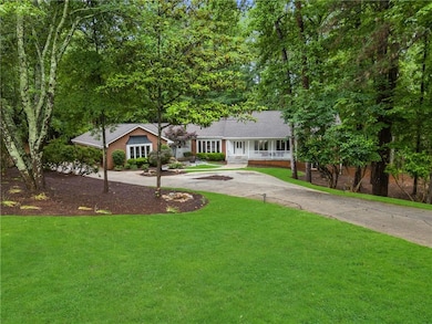 Ranch-style house featuring curved driveway, a front lawn, and a porch