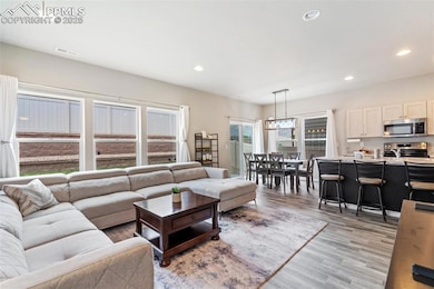 Living room with recessed lighting and light wood-style flooring