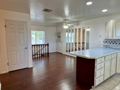 Kitchen featuring tasteful backsplash, light countertops, a ceiling fan, a textured ceiling, and plenty of natural light