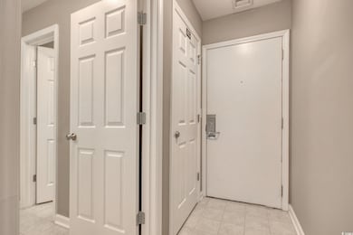 Hallway featuring light tile patterned flooring, b