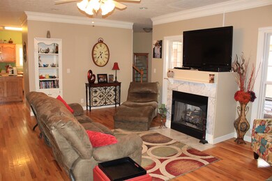 Living Room w/ Gas fireplace, built-in cabinet, & crown molding