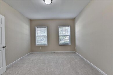 Spare room featuring light colored carpet and baseboards