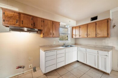 Kitchen with light tile patterned flooring, white 