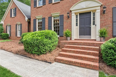 Entrance to property featuring brick siding and a shingled roof
