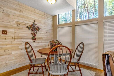 Dining area featuring a textured ceiling, wood wal