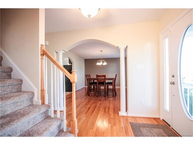 Entry with gleaming hardwoods, columns, arched doo